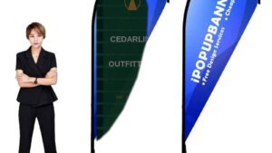 Custom teardrop flag banners with Cedarline Outfitters invent branding beside a person for scale, closed slender loop fabric returning to the pole, cross base with water bag and ground spike shown