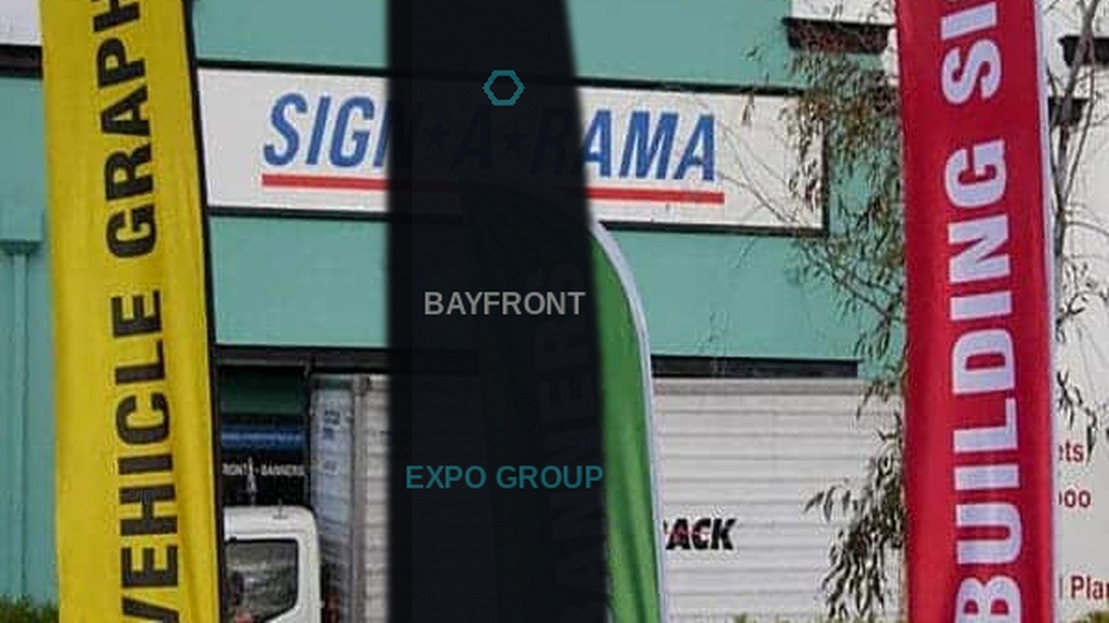 Multiple custom feather flags with ground spikes on a commercial lawn, Bayfront Expo Group invent branding on the center blade flag